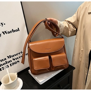 Detail view of the vintage brown PU leather shoulder bag with two front square pockets