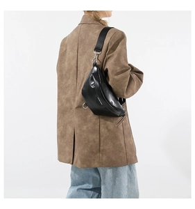 Detail of minimalist black PU leather moon bag with wide nylon strap on model
