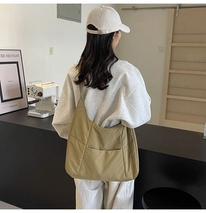 Quilted fabric shoulder bag in khaki featuring padded texture and wide strap design