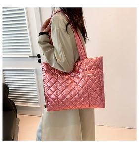 Detail of metallic bright pink quilted tote bag with diamond stitching and high gloss finish
