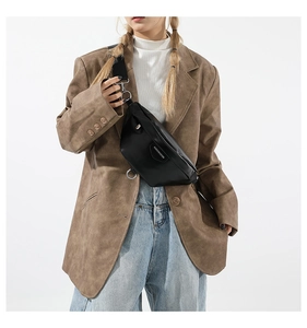 Detail of minimalist black PU crossbody bag styled with casual brown blazer and jeans