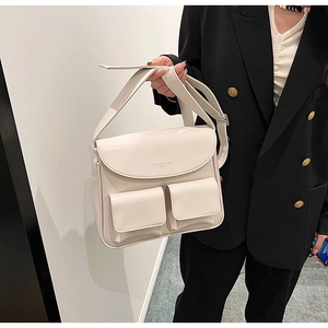 Detail of cream PU leather shoulder bag with double front pockets and embossed fashion text