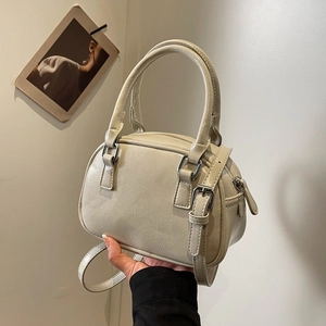 Close-up of cream PU leather bowling bag with silver buckles and adjustable strap