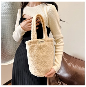 Detail of plush lamb wool handbag in beige white featuring minimalist woven brand label