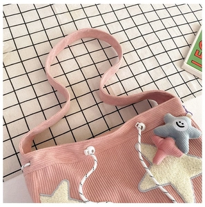 Details van roze corduroy draagtas met sterborduursel en een schattige pluche hanger