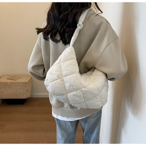 Quilted white shoulder bag shown on model for size perspective in lifestyle setting