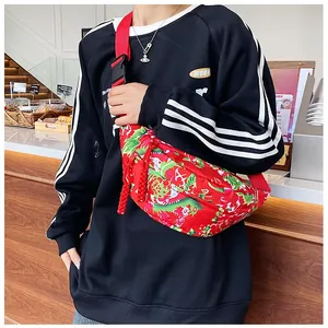 Detail of red floral nylon crossbody bag with traditional patterns and adjustable strap