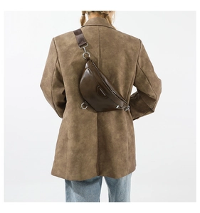 Detail view of the deep brown PU leather chest bag worn across the back by a model