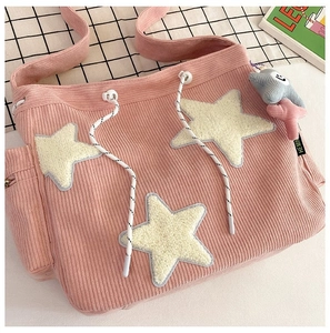 Detail van roze corduroy tote bag met gele sterren en een pluizige sterhanger
