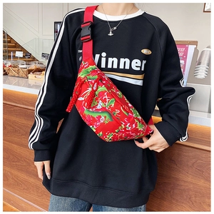 Detailed close-up of dragon and floral pattern embroidery on red nylon crossbody bag