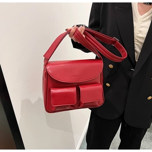 Detail of red PU shoulder bag with double square front pockets and wide strap