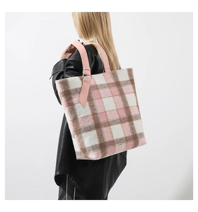 Dettaglio della borsa tote in lana a quadri rosa e marroni indossata dalla modella