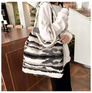 Detail view of large faux fur tote bag with black white grey texture on model shoulder