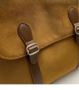 Detail of mustard yellow suede bag with vintage brown leather strap and gold buckle