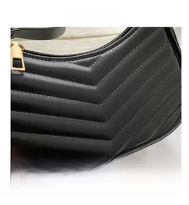 Close-up of black PU leather shoulder bag with chevron quilting and gold zipper detail