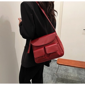 Detail of a dark red PU leather shoulder bag featuring dual magnetic front pockets
