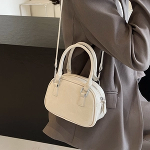 Close-up of cream PU leather handbag with silver hardware and adjustable strap detail