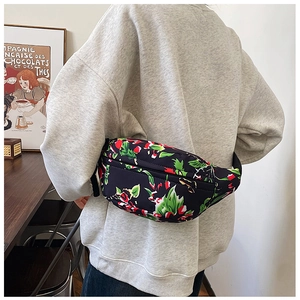 Detail of floral nylon crossbody bag with adjustable strap worn by model in a room