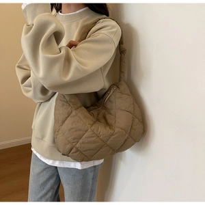 Detailed macro view of quilted rhombus pattern and shoulder strap on the dark khaki bag