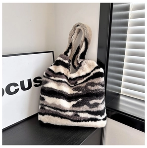 Close-up of zebra pattern plush shoulder bag with soft faux fur texture and modern chic style