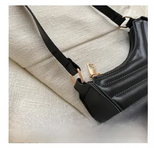Close-up of the black quilted leather bag showing golden D-ring and metal zipper details
