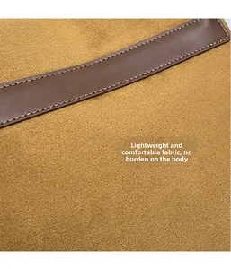 Close-up of yellow suede fabric and brown leather trim with white stitching details