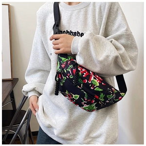 Detail of floral nylon crossbody bag featuring adjustable strap and buckle closure