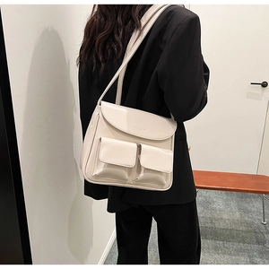 Minimalist cream white PU leather handbag with dual front pockets on a shoulder strap