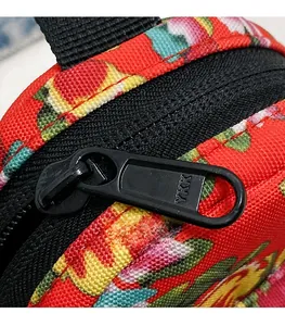 Detailed macro view of the premium black YKK metal zipper on a floral canvas crossbody bag