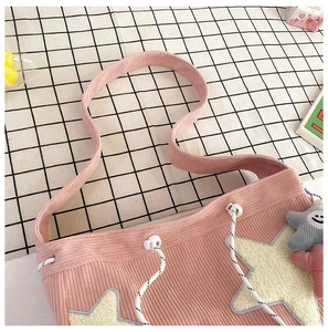 Detail van de roze corduroy tote bag met witte ster-patch en trekkoordsluiting