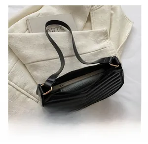 Detail view of the spacious interior of a black quilted leather baguette bag with a smartphone