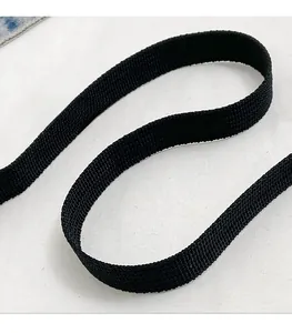 Detail of a durable black woven nylon shoulder strap with a dense twill texture for handbags