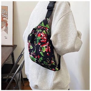 Detailed view of black nylon crossbody bag featuring floral pattern and adjustable strap