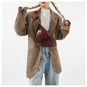 Minimalist burgundy PU leather crescent crossbody bag shown on a vintage brown blazer
