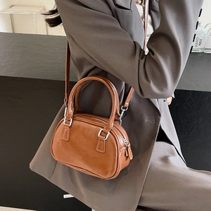 Detailed close-up of brown PU leather handbag texture with silver metal buckles