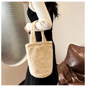 Chic beige faux fur handbag with plush texture and woven logo tag for winter style
