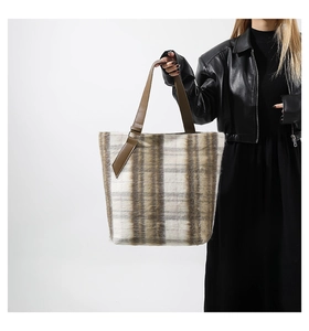 Dettaglio della borsa tote in lana scozzese con trama felpata e manici in pelle PU marrone
