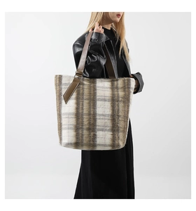 Dettaglio borsa shopper in lana a quadretti con trama soffice e manico in pelle marrone
