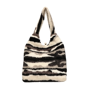 Fuzzy faux fur tote bag featuring black and white abstract patterns with magnetic closure