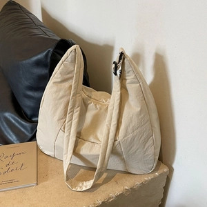 Minimalist beige quilted crossbody puffer bag with adjustable wide strap and zipper