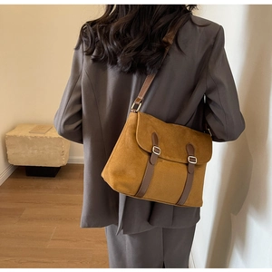 Model showing caramel velvet crossbody bag with leather strap and metal buckle