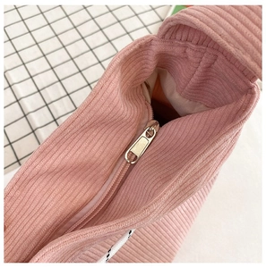 Detail van metalen rits en corduroy textuur op de roze corduroy tas