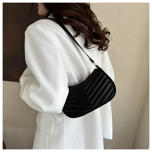 Detail of black PU leather shoulder bag with V-shaped quilted stitching and golden zipper