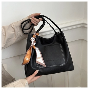 Detail of black pebbled leather tote bag with braided handle and decorative silk scarf