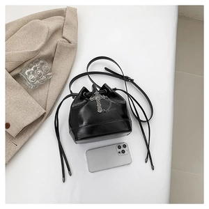 Minimalist black PU leather drawstring bucket bag with silver cross chain and slim shoulder strap