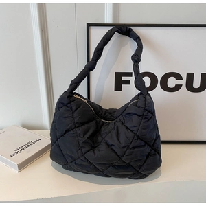 Chic black quilted puffer shoulder bag with a knotted strap and sleek zipper closure