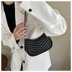 Close-up of black crescent-shaped underarm bag with elegant V-shaped quilting detail