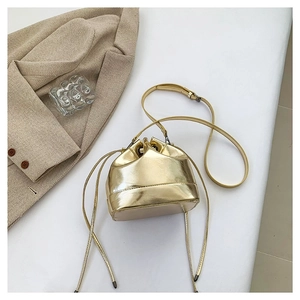 Metallic gold drawstring bucket bag with adjustable shoulder strap on white background