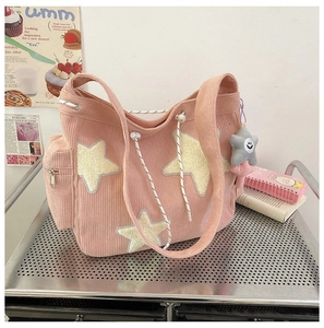 Detail van de roze corduroy tote tas met gele ster-patches en grijze pluche hanger