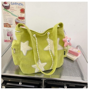 Detail van lichtgroene corduroy draagtas met pluche sterren en zijvak met roze hanger